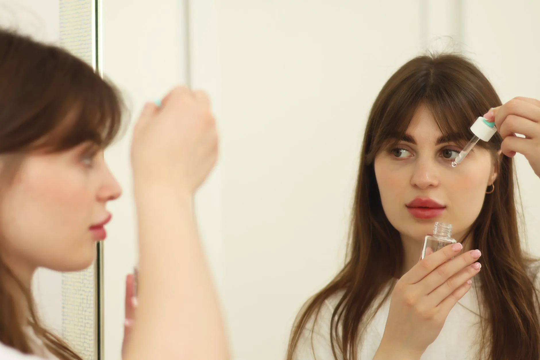 Người phụ nữ thoa serum dưỡng da lên mặt