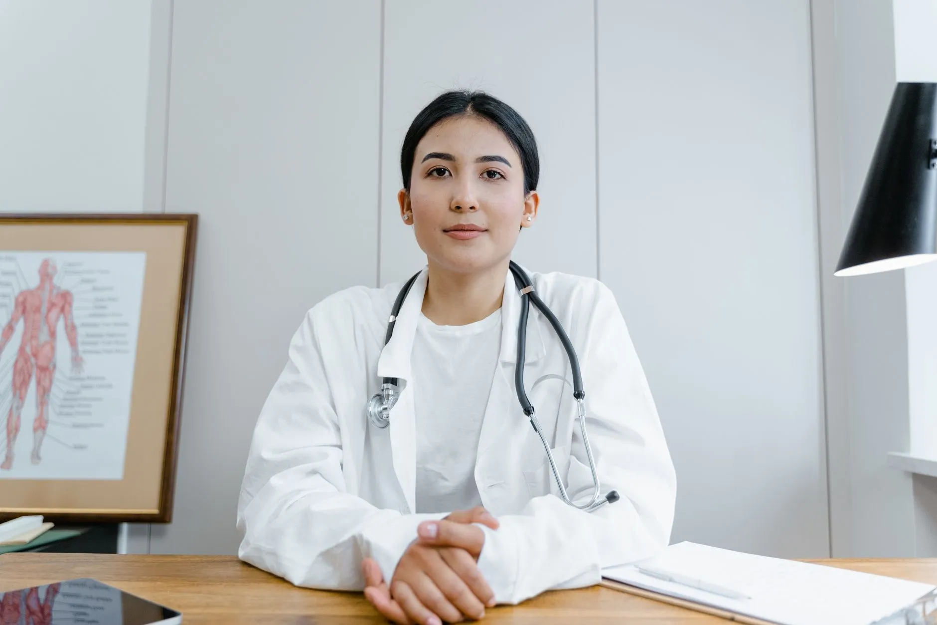 Bác sĩ nữ đang tư vấn cho một phụ nữ trẻ tại bàn khám, cả hai nhìn vào tờ ghi chú.