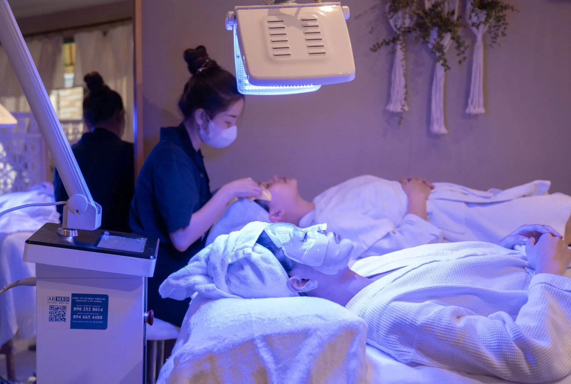 Người phụ nữ dùng mặt nạ ánh sáng LED chăm sóc da