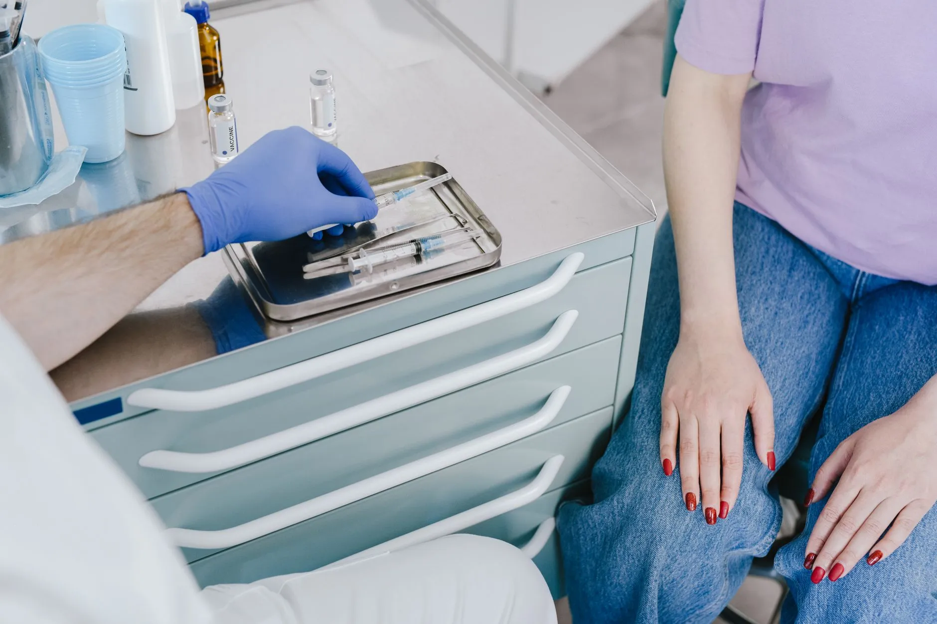 Nhân viên y tế chuẩn bị dụng cụ tiêm trong phòng thủ thuật.