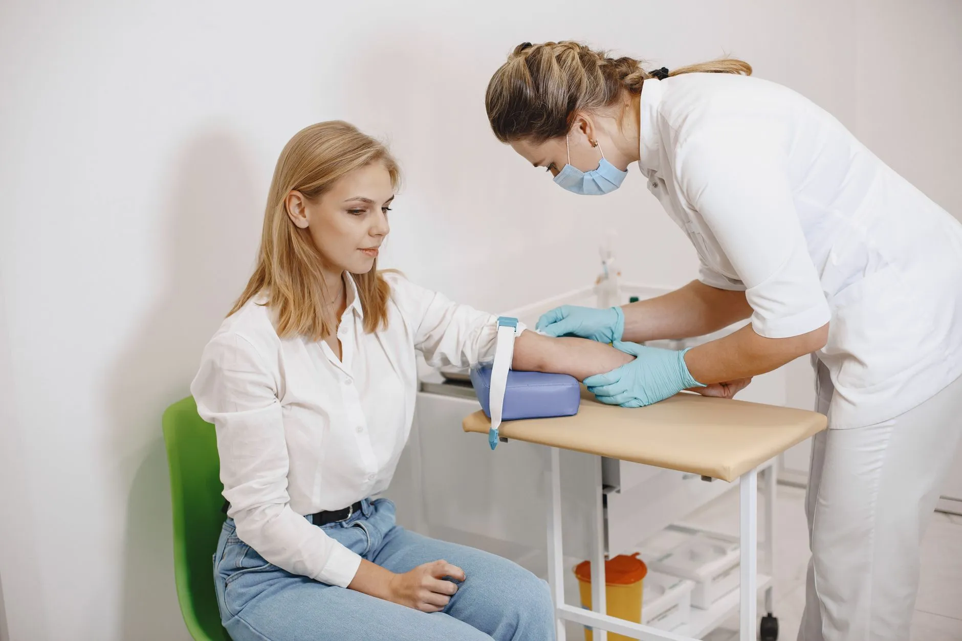 Nhân viên y tế lấy máu xét nghiệm ở cánh tay người bệnh tại phòng khám.